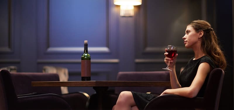 kobieta pijąca w samotności wino